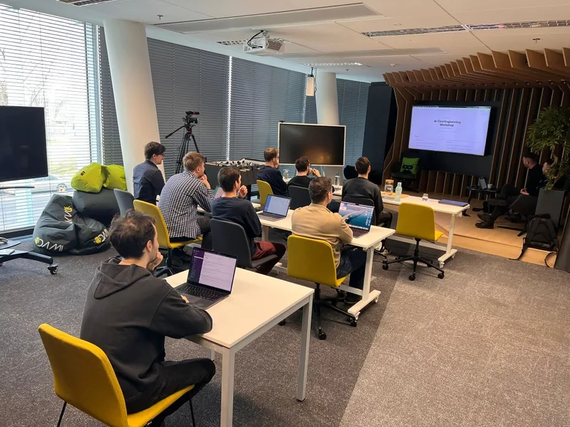 Firemní AI workshop: tým s notebooky v moderní školící místnosti s prezentací na obrazovce